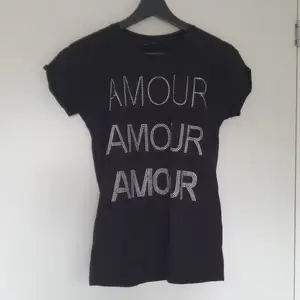 T-shirt med texten AMOUR på framsidan svart baksidan 