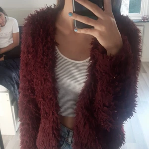 Kofta - Har använts men ser ut som ny. Vinröd och fluffig väldigt mjuk och håller dig varm. Storlek S