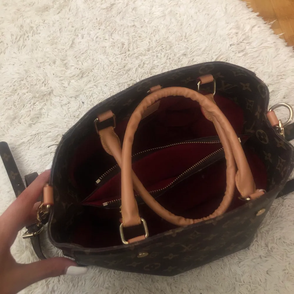 En Louis Vuitton väska som är en kopia i bra skick jätte fräsch och har brett utrymme för att ha saker där i. . Väskor.