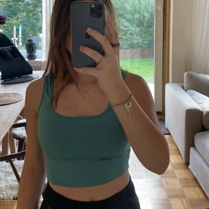 blå/grön linne - En croppad topp/linne i färgen blå/grön, matrialet är mjukt och sitter väldigt bra. 