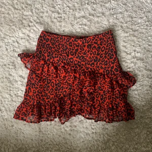 Volangkjol - Super söt röd volangkjol med leopardmönster. Köpt på bikbok för några år sedan. Kjolen är knappt använd, alltså väldigt bra skick. KÖP DIREKT FÖR 130 KR! 