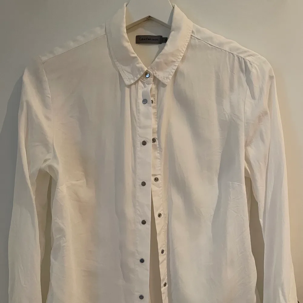 Vit skjorta med tryckknappar från Calvin Klein Jeans, storlek S. Skjortor.