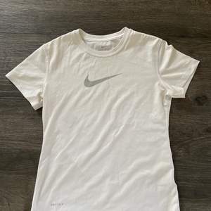 En vit träningströja med ett grått Nike märke på bröstet. Mycket bra kvalite och är aldrig använd 