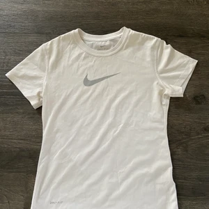 Träningströja i storleken 10-12 år - En vit träningströja med ett grått Nike märke på bröstet. Mycket bra kvalite och är aldrig använd 