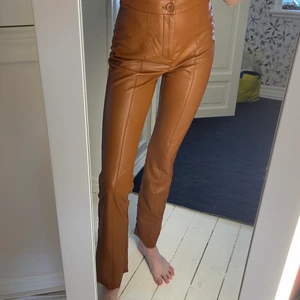 Skinnbyxa  - Skinnbyxa i fakeläder. Kick flare modell och en lite stor i storleken. Är 171 cm för referens