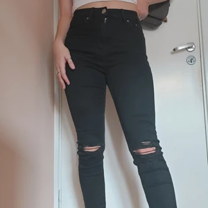 Svarta skinnyjeans - Ett par svarta skinnyjeans med hål vid knäna och hög midja. Köpt på Lager 157. Görsnygg passform som får benen att se långa och snygga ut👀. De är aldrig använda eftersom jag köpte två par men nu är de inte riktigt min stil längre och därför säljer jag! Köparen står för frakten men jag kan också mötas upp i gbg😇❤