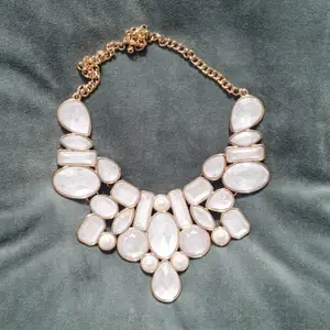 Coolt, tungt halsband i guld, pärlor och ädelstenar (inte äkta). Snyggt till monokrom outfit!