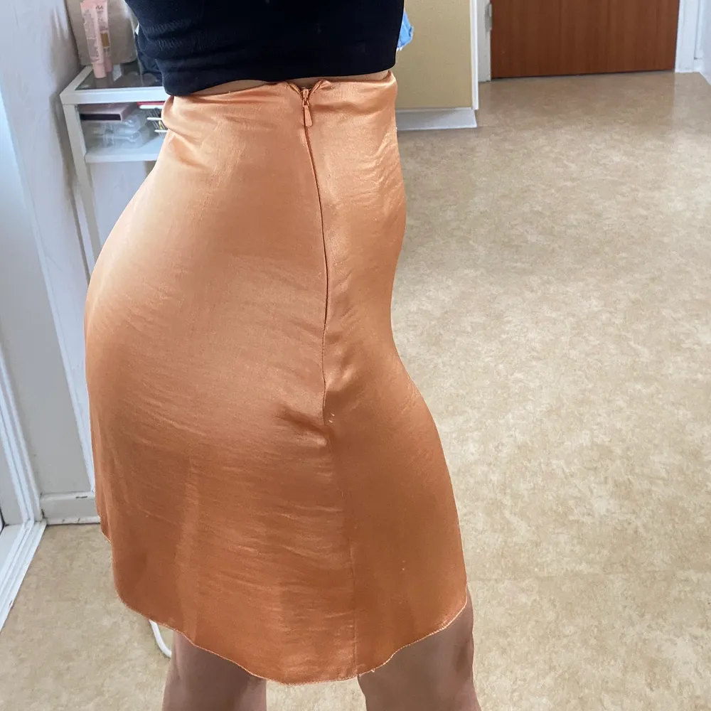 Asymmetrisk satin kjol från asos i en ”peach”/orange färg. Färgen är starkare irl än på bild. I strl 36 men säljer pga lite för liten för mig som är mellan 36-38. Jag är 163 cm. Aldrig använd!. Kjolar.