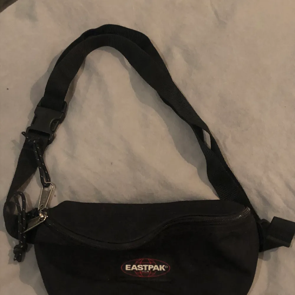 Det här är en svart bumbag från märket eastpack. Den har justerbart band. . Väskor.