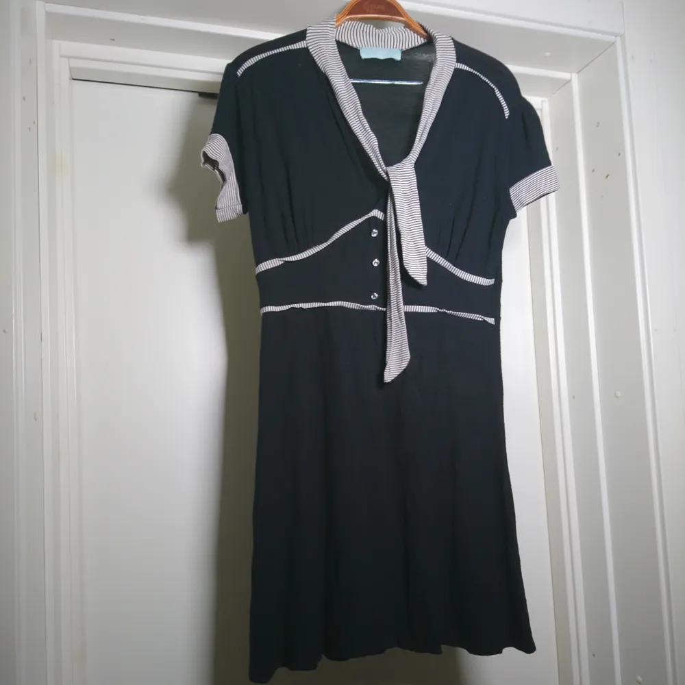 Svart vintageklänning med svart/vit-randiga detaljer och 