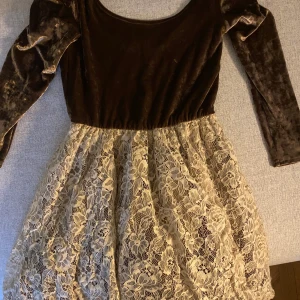 Klänning från Twist&Tango - Använt skick, beige och bronsfärgad. Topp i sammet, kjol i spets med en underkjol i tyll. 