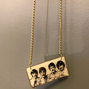The Beatles halsband - The Beatles halsband, lång guldfärgad kedja., lätt att ställa om längden på. Storlek på bilden är: 6.8cm* 3.5cm