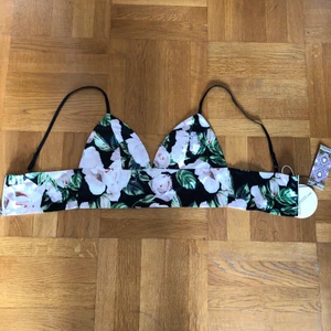 Somrig blomtopp  - Supersnygg blommig topp från boohoo. Säljer eftersom jag personligen tycker att kuporna är lite för små för mina bröst. Aldrig använd, prislappen är kvar. Köparen står för frakt.