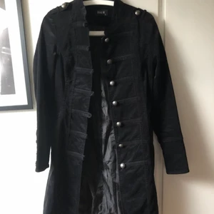 Kappa i band-jacket stil - Köpt här på Plick men inte kommit till användning. Nyskick. Fin sammet med massa knappar, ett par sidofickor. Går ner till knäna på mig som är 156cm.