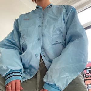 Turkos bomberjacka! - En turkos bomberjacka i satin med gula detaljer! Fett nice man lyser med den på😍😍 från USA på 80 talet. Går att steama. 