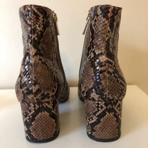 Stövletter i ormskinnsmönster - Stövletter i ormskinnsmönster. Går att stänga med dragkedja. Storlek 37. Använda en gång.