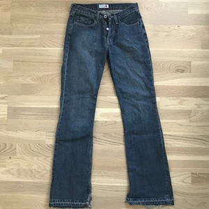 Lågmidjade Tommy Hillfigure jeans - Ett par asballa lågmidjade Tommy Hillfigure jeans som är utvängda med slits vid anklarna. Jag är 175cm och de är perfekt längd, alltså de går lite över skon precis som man vill.🤩 det är storlek 28/32 men passar även 27 vid midjan. Köparen står även för frakten (ingår ej i priset).💗💗