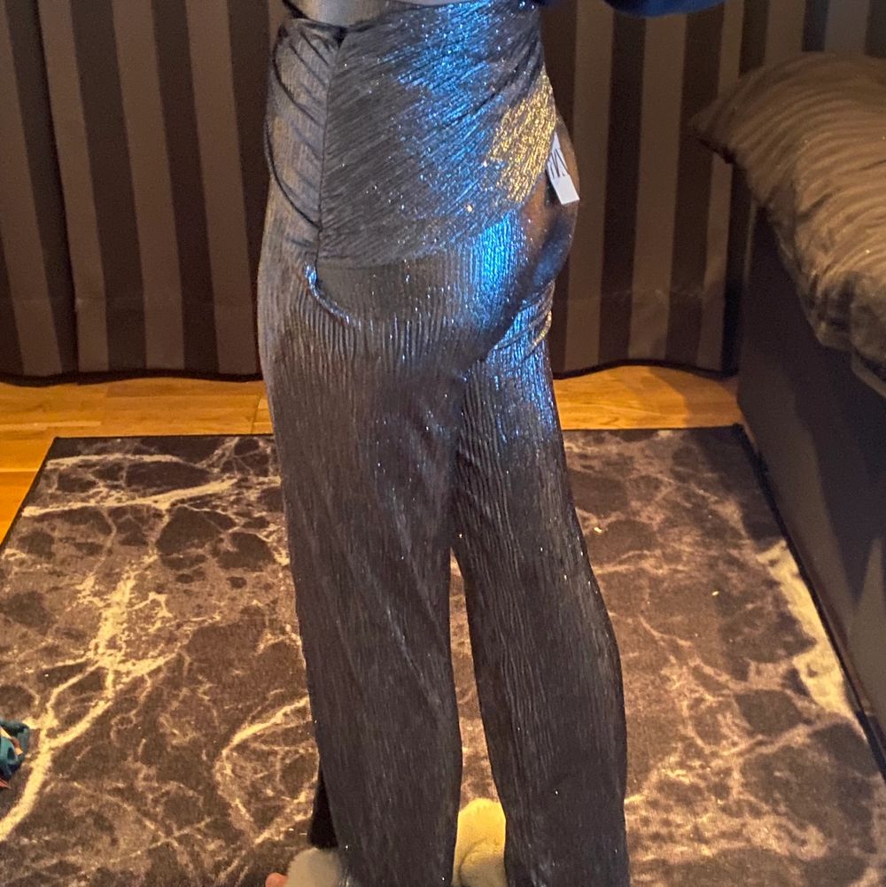 Ssuuuupercoola glittriga byxor från zara, ena benet är vanlig byxa och andra benet är slits som man knyter, aldrig använda tyvärr, det är svårt att ge en uppriktig bild av hur byxorna egentligen ser ut på så skriv för fler bilder så skickar jag!! 🌸 . Jeans & Byxor.