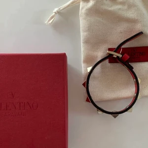 Rött Valentino armband  - Säljer eftersom att jag vill köpa en annan färg. One size/justerbart passar alla. Använt men i bra skick. Har dustbag och box men inget kvitto. Kan garantera att det är äkta, har stämpel osv. Köp direkt för 1400kr , men buda från 250kr. Säljer endast för bra pris