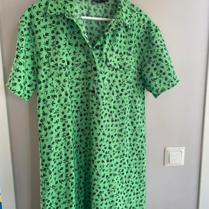 Grönmönstrad långklänning, storlek S - Jättecool grön långklänning i skjortmodell, slits på båda sidor. Använd vid ett tillfälle! 