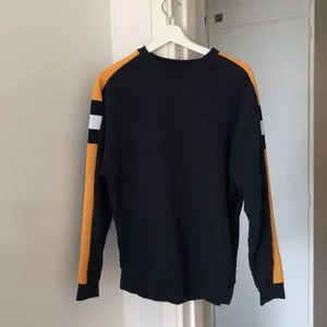 Mörk blå sweatshirt  - Mörkblå sweatshirt i storlek XS med gula detaljer på armarna men sitter ändå inte tight. 