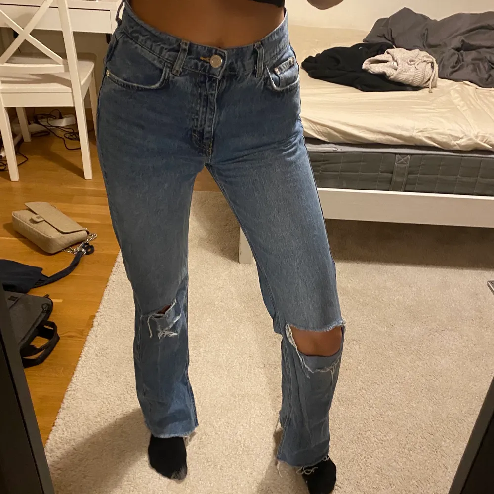 Mid/high rise jeans från pull&bear med hål och slitningar i knäna och slits där nere i storlek 36. Sitter väldigt bra och är långa! Jag är 176 cm lång och har normalt storlek S! 💗Bra skick!. Jeans & Byxor.