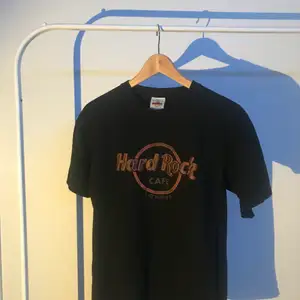 En svart Hard Rock Café t-shirt med tryck i läder, storlek small. Hard Rock Cafe t-shirt med tryck som står ut, från London.