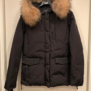 Hollies vinterjacka - Vinterjacka från Hollies med äkta päls som går att ta av. Många användbara fickor och stor luva. Använd en säsong så den är i väldigt bra skick. Storlek 46 passar storlek 44-46. Nypris 4899kr. INGA BYTEN.