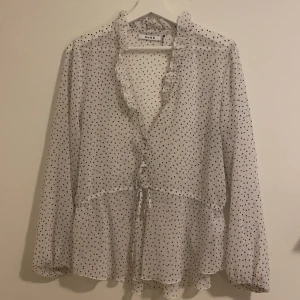 Prickig blus  - En vit, lätt genomskinlig, prickig blus från na-kd i storlek 40