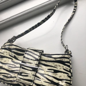 Zebra baguette väska - Baguetteväska från asos som lyser i mörkret, använd fåtal gånger (i princip i nyskick!) 