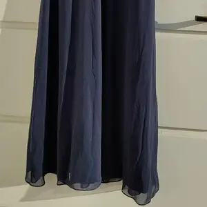 Långklänning använd endast en gång på bal. Fin spets i mörkblå. (Fick tyvärr inte med en helbild men den är lång). Passar S-M. 