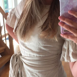 Beige klänning med volang - En beige klänning med volangdetaljer och knytning i midjan, supersöt men tyvär för kort för mig😆bara att skriva vid önskan av fler bilder, köparen står för frakt☺️