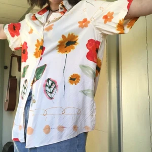 kortärmad skjorta - kortärmad skjorta med fina blommor i rött, gult och grönt! står ingen storlek men passar xs-l. 100% viskos. troligen vintage. skön och luftig, perfekt till sommaren.