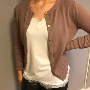 Kofta med guldknappar och gulddetaljer i ärmarna  - Fin kofta med gulddetaljer. 49% viscose och 22 % polyester