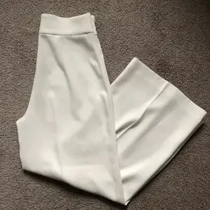 Vita kostymbyxor från zara i tjockt men luftigt material. Byxorna är i culotte modell (alltså inte full lenght) och en aningen vida med pressveck. Använd endast två gånger och är i nyskick🤍 Helt slutsålda och nypriset var 499kr 