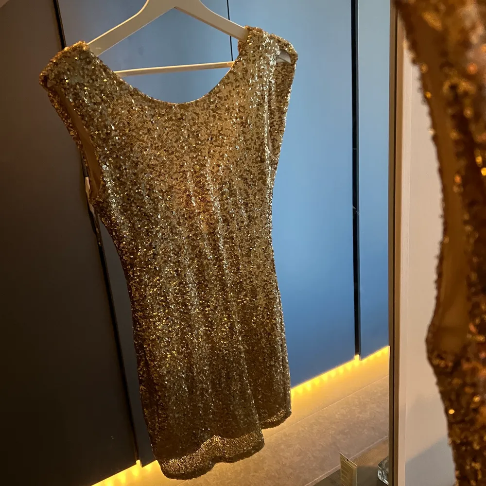 Drömklänning i guldiga paljetter😍  Den går att ha åt båda hållen, både med vattenfallsringning fram och bak i ryggen! . Klänningar.