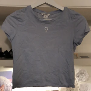 Topp från monki - En ljus blå topp från monki💕 Det är ett kvinnotecken på framsidan. Färgen är lite ljusare än på bilderna och storleken är lite större än xxs tycker jag💕 Fråga gärna om fler bilder!💗