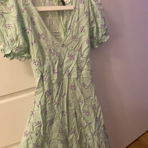 Klänning - Supersöt klänning i fina pastellfärger! Den har ett snöre man kan knyta i bak som framhäver kroppens form, och en dragkedja i bak! Den passar helt perfekt på sommaren och är sjukt skön då den inte alls är varm att ha på sig!