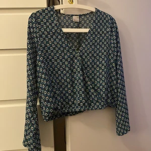 Omlott topp - En snygg omlott topp med ett coolt blått / turkost mönster. Lite meshaktigt tyg men inte genomskinlig. Perfekt till sommaren!