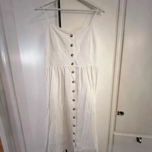 Vit sommarklänning  - Perfekta klänningen att slänga på sig en sommardag, utan att känna att man klätt upp sig för mycket. Eller varför inte till studenten? Sparsamt använd, inga skador. 