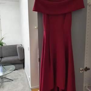 En vinröd klänning. Lång där bak och kortare framför. Har använts en gång tidigare. Tyget är tjockt, vilket innebär att man kan använda klänningen i vintersäsongen. Orginala pris, 300 kr. Kontakta för mer info. 