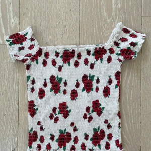 Hollister Top  - Söt top fr Hollister. Stl xs. Vit med röda rosor. Fint och fräscht skick!