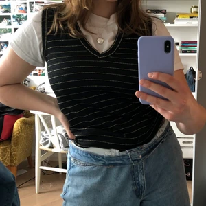 Svart stickad väst med gulddetaljer - Svart väst med guldiga detaljer, ganska tunn så funkar till våren! Köpt second hand så vet inte storlek men skulle säga XS-M beroende på hur man vill att den ska sitta