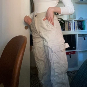 Monki beige byxor - Beige byxor från monki med två stora fickor där fram. 