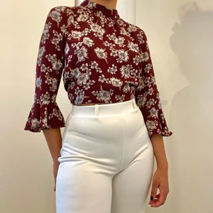 Blommig vinröd blus - Blommig vinröd blus med volangärmar från Ginatricot i storlek XS 