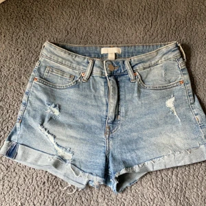 H&M Ripped Jeans Shorts strl. 38 - Jag säljer ett par Ripped Jeans Shorts i storlek 38 från H&M. Dem köptes i somras men är använda en eller två gånger. Dem är i bra skick och ser ut som dem gjorde när dem var nyköpta. Skriv i kommentarsfältet vid intresse! 🤍Kram