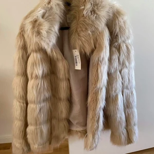 Oanvänd fuskpälsjacka - Helt ny fuskpälsjacka från Nelly med tags på (köpt för 900kr)
