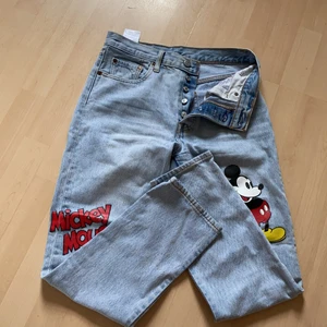 Levis 501 Mickey Mouse - Sällan använda och i bra skick, passformen är som vanliga 501or. Strl: W:27 L:28. Jag som har 36/38 kan ha dom.