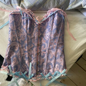 Korsett  - Fin lila korsett med rosa blå detaljer super söt men fick dubbla storlekar så säljer denna som är helt oanvänd kommer i original förpackning finns även i XL