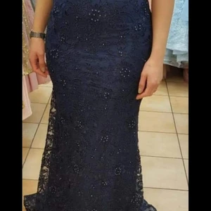 En supersnygg tight klänning i mörkblå med fina detaljer över hela plagget.  - Passar storlek 36/38